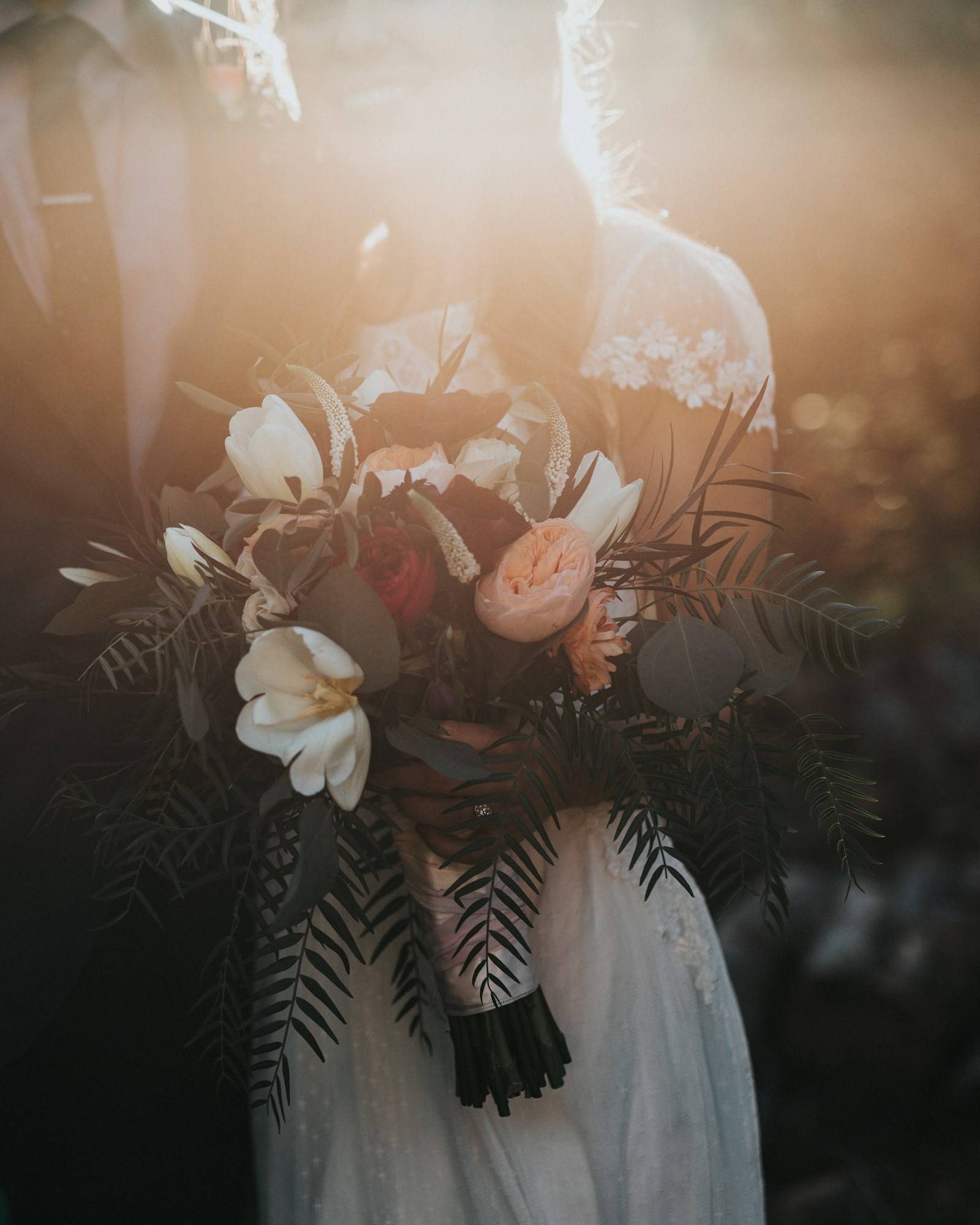 The couple holding the bridal bouquet before the ceremony