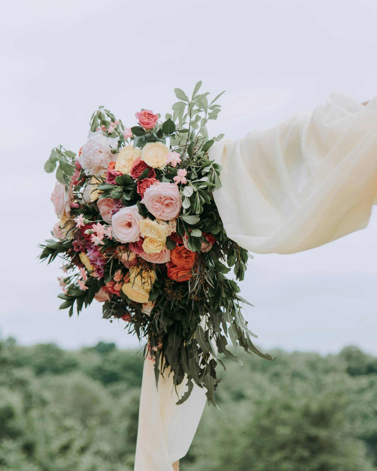The bridal bouquet hung against a whitewashed wall